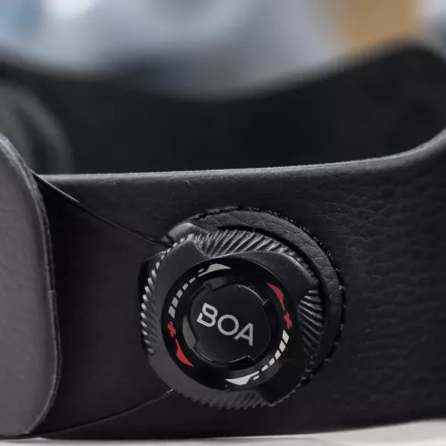Close-up of the BOA micro-adjustable dial and aircraft-grade stainless steel laces on a wrist-to-elbow brace, showing how the tension system provides a custom, secure fit